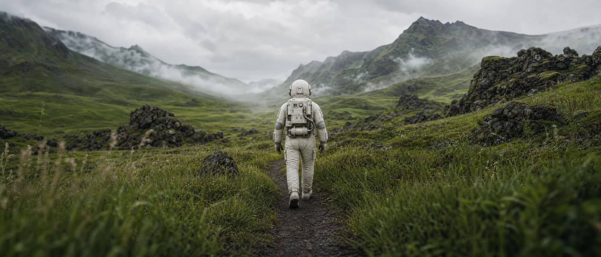 Der Astronaut geht auf einem schmalen Pfad durch ein grünes, nebliges Tal.